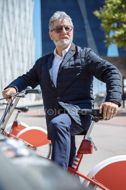 Homme âgé posant avec un vélo — Photo de stock