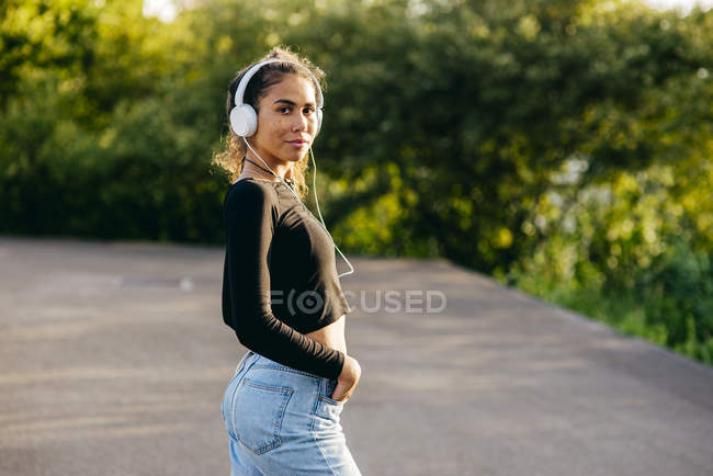 Hermosa chica confiada en los auriculares - foto de stock