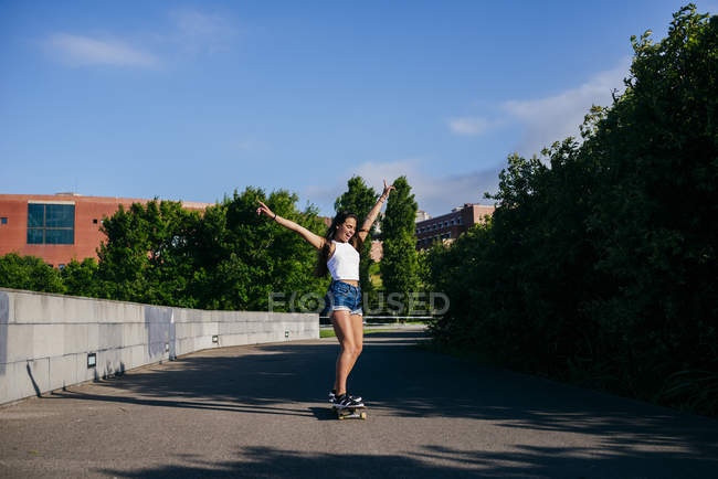 Возбужденная девушка на коньках в парке — стоковое фото