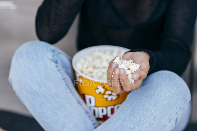 Crop girl with popcorn in hand — Stock Photo