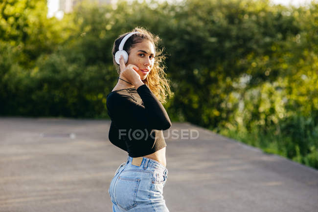 Красивая уверенная девушка в наушниках — стоковое фото