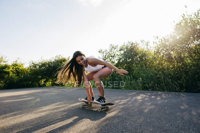 Teen riding skateboard in sunlight — Stock Photo