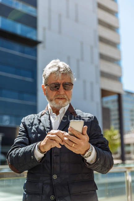 Elegante anciano con smartphone - foto de stock