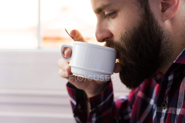 Вид сбоку на человека, пьющего кофе — стоковое фото