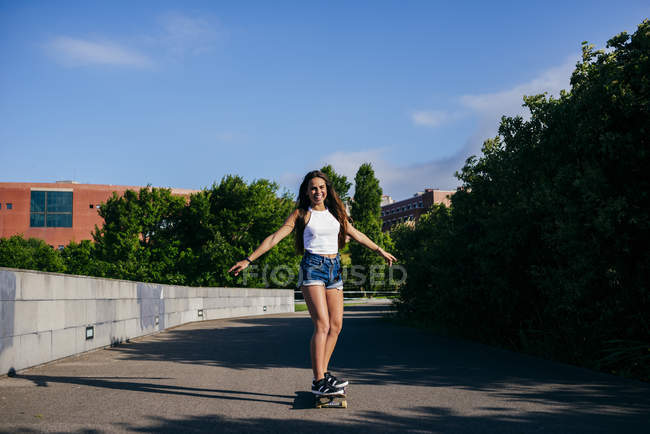 Garota excitada no skate no parque — Fotografia de Stock