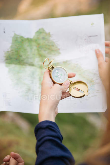 Женская рука с компасом и картой — стоковое фото