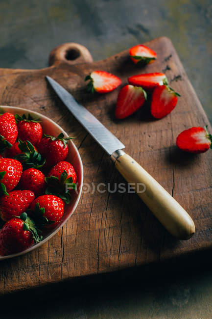 Cutting strawberries on cutting board — Stock Photo