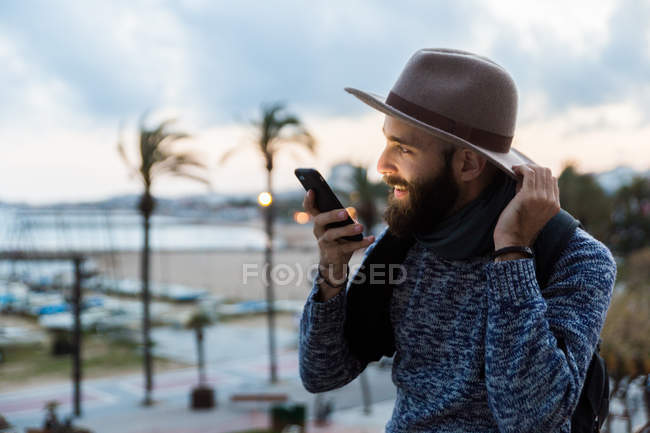 Молодий усміхнений чоловік розмовляє телефоном — стокове фото