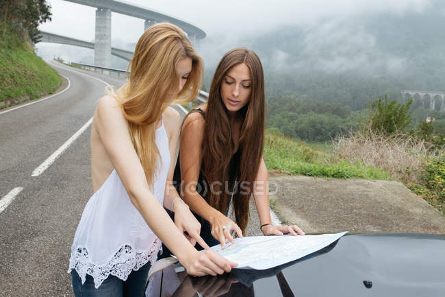 Two girls looking in map on road — Stock Photo
