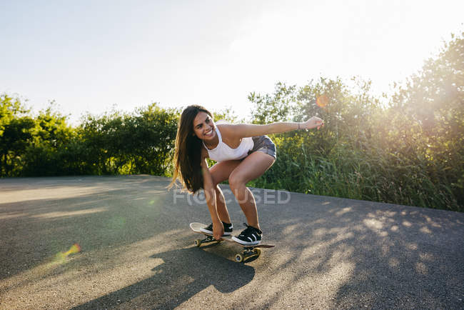 Підліткові скачки скейтборд на сонячному світлі — стокове фото
