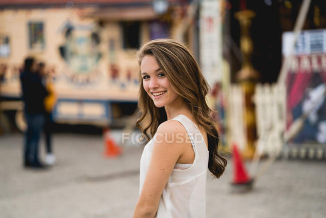 Молодая улыбающаяся девушка смотрит в камеру — стоковое фото