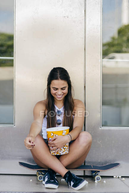 Ragazza affascinante con popcorn su skate — Foto stock