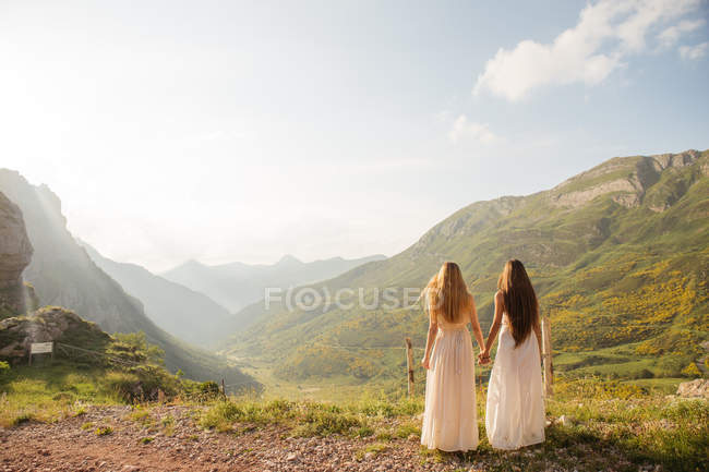 Two girls hugging over moutain sunset — Stock Photo