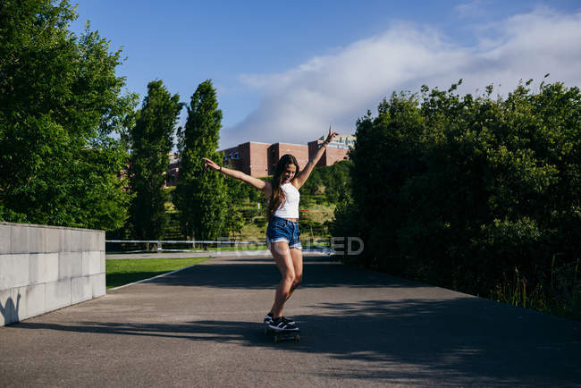 Garota excitada no skate no parque — Fotografia de Stock