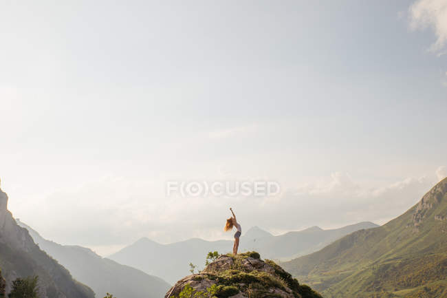 Woman posing on mountain top against of amazing sky — Stock Photo