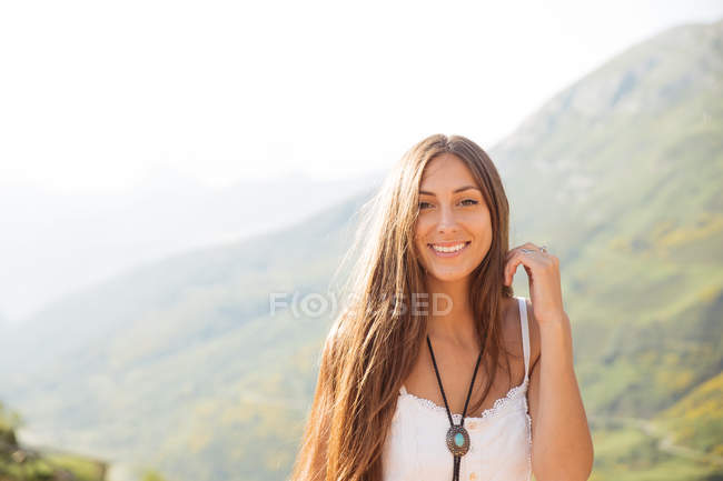 Chica en vestido blanco ajustando el cabello - foto de stock