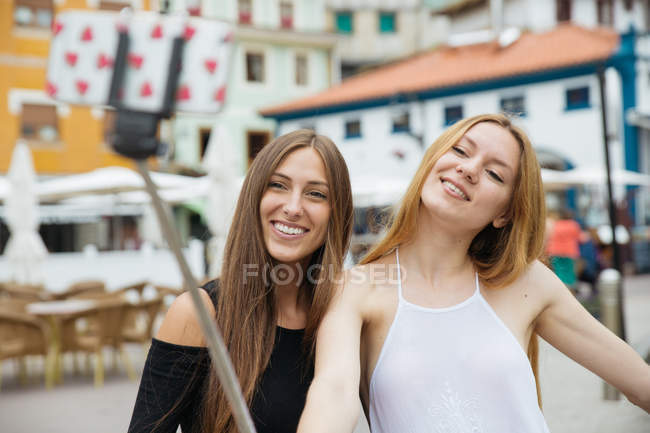 Two girls taking selfie over cityscape — Stock Photo