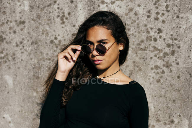 Модна дівчина дивиться сонцезахисні окуляри — стокове фото