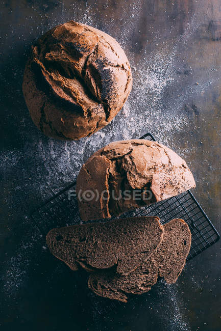 Mains de pain rustique sur sombre — Photo de stock