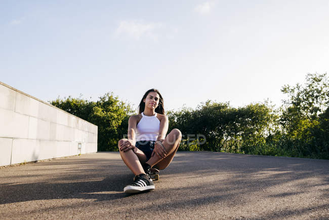 Jeune assis sur le patin — Photo de stock