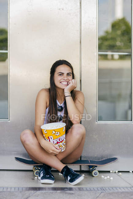 Ragazza affascinante con popcorn su skate — Foto stock