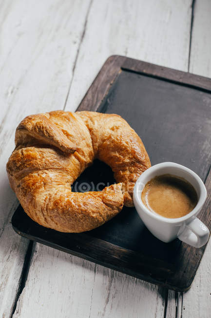 Кофейная чашка эспрессо и круассан — стоковое фото