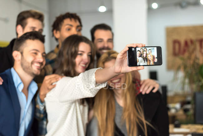 Equipo de oficina haciendo selfie en la cámara del smartphone . - foto de stock