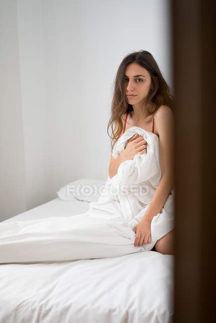 Fille posant dans le lit sous couverture — Photo de stock