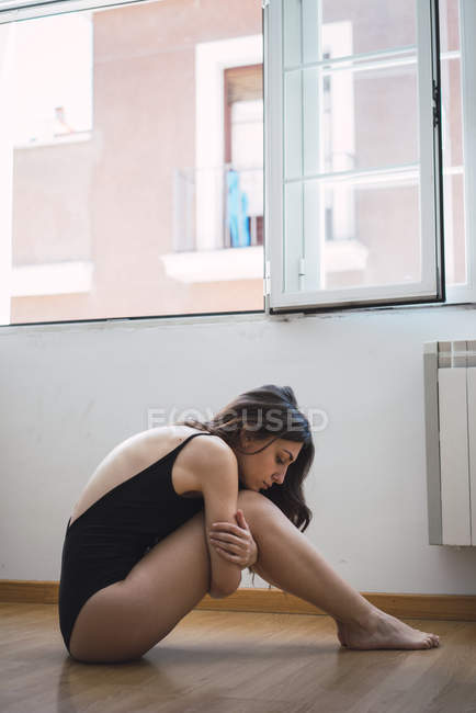 Vue latérale de la femme posant sur le sol — Photo de stock