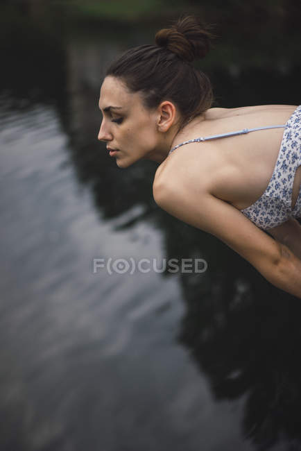 Girl bending forward above water — Stock Photo