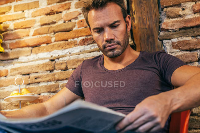 Чоловік читає газету вдома — стокове фото
