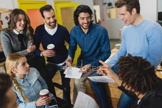 High angle view of smiling people with papers while meeting in office — Stock Photo