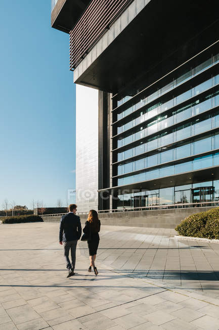 Business Couple Walking in Street Besides Financial building — Stock Photo