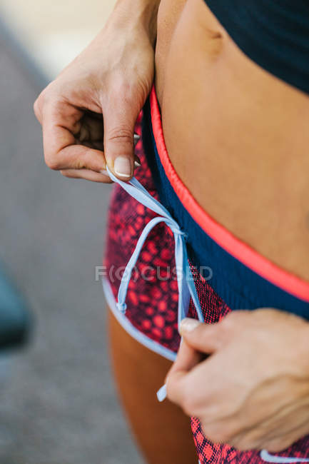 Woman tying lace on shorts — Stock Photo
