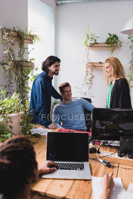 Portrait of smiling colleagues at workplace in office. — Stock Photo