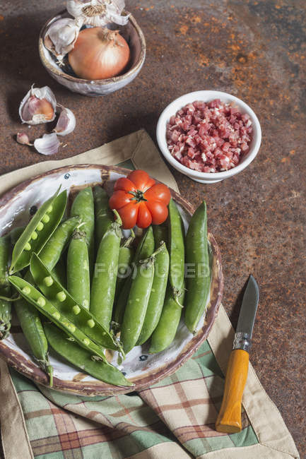 Fresh and raw green peas with ham — Stock Photo