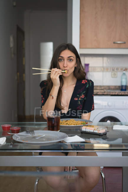 Усміхнена дівчина їсть локшину — стокове фото