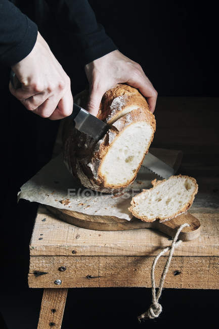 Donna che taglia pane fatto in casa — Foto stock