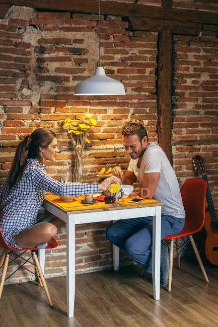 Jovem casal tomando café da manhã — Fotografia de Stock