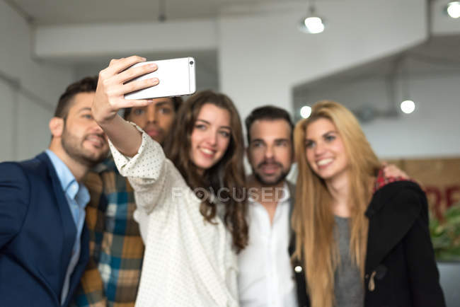 Equipo de oficina haciendo selfie en la cámara del smartphone . - foto de stock