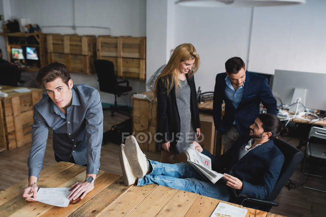 Portrait of man signing papers and looking at camera at modern office — Stock Photo
