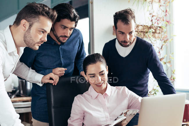 Femme d'affaires coopérant avec ses collègues sur le lieu de travail dans un bureau moderne — Photo de stock