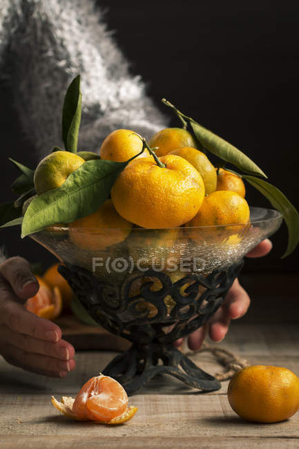 Woman picking a fruit bowl with tangerines — Stock Photo