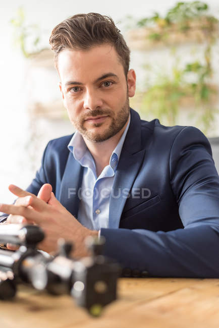 Confident businessman sitting at workplace  and looking at camera — Stock Photo