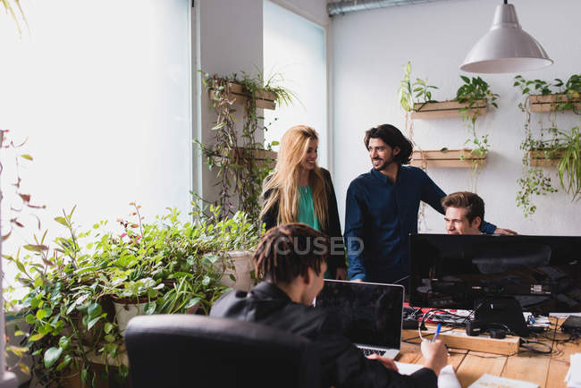 Офісна сцена працівників, що спілкуються на робочому місці — стокове фото