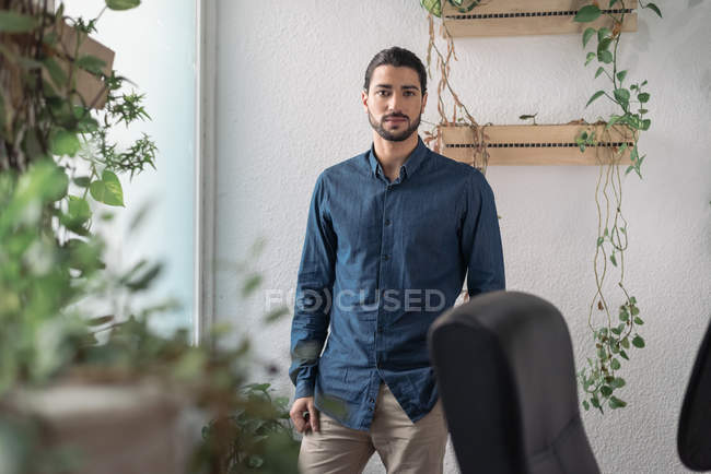 Porträt eines Geschäftsmannes, der am Fenster steht und in die Kamera schaut — Stockfoto