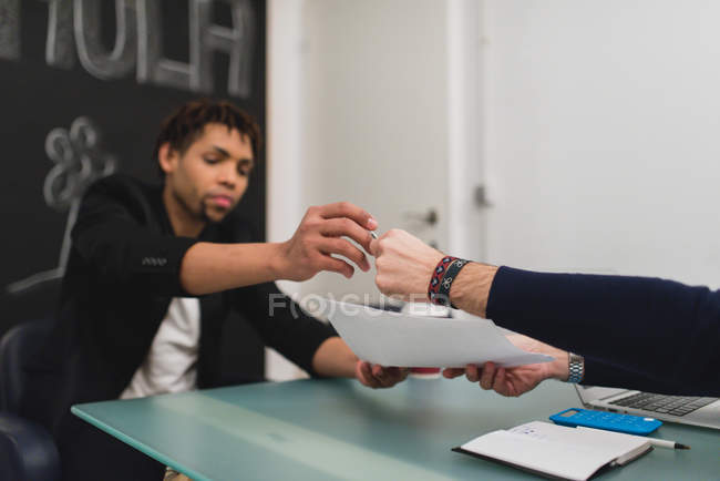 Crop hand of giving a pen to business partner to sign papers — Stock Photo