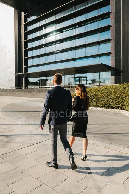 Вид на деловую пару, идущую по улице — стоковое фото
