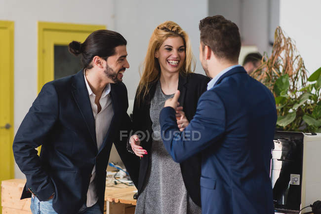 Portrait of laughing people talking to each other at office — Stock Photo