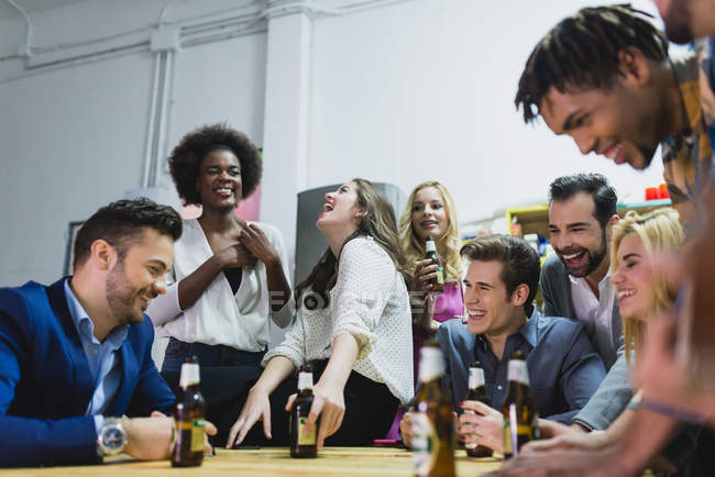 Vista a basso angolo di persone che bevono birra in ufficio mentre fanno squadra — Foto stock